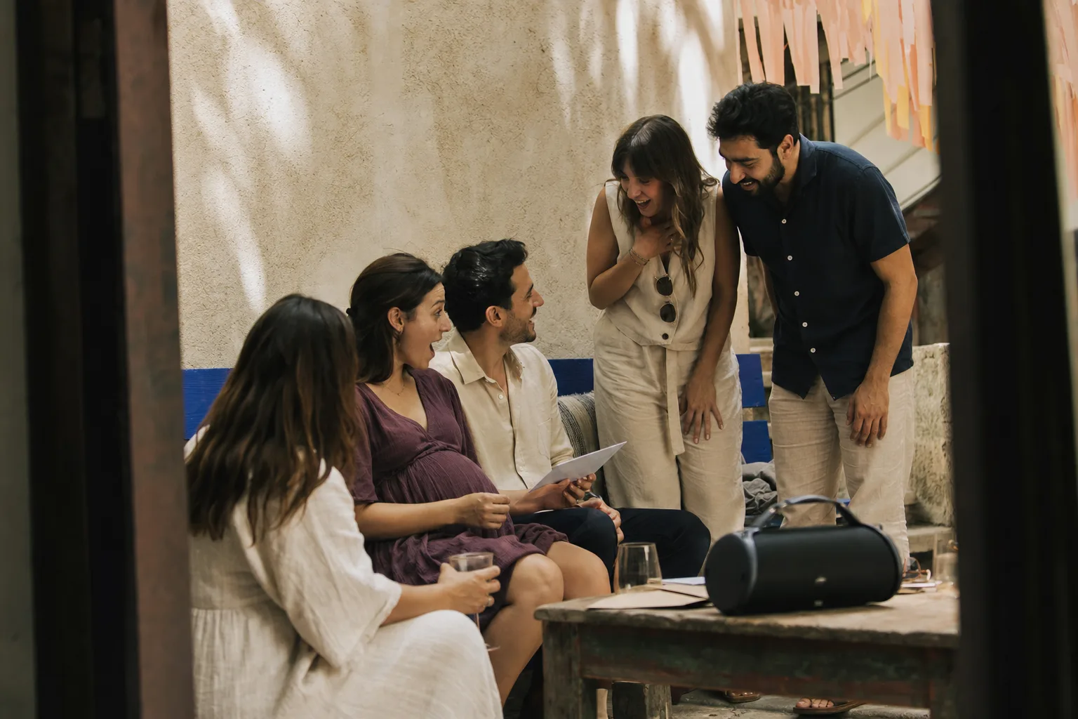 Friends listening together at an afternoon courtyard baby shower