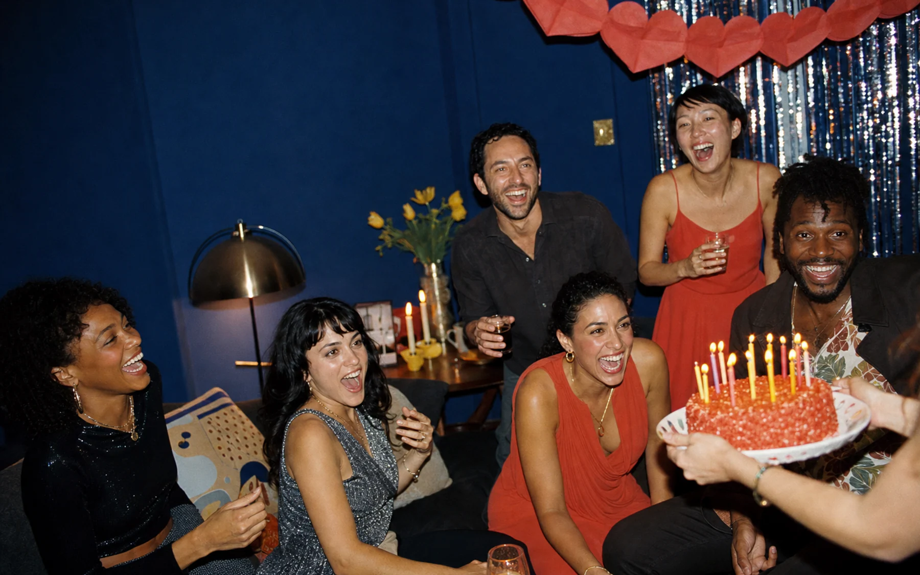 Flash-lit analog birthday party with coral decorations and a cobalt blue backdrop