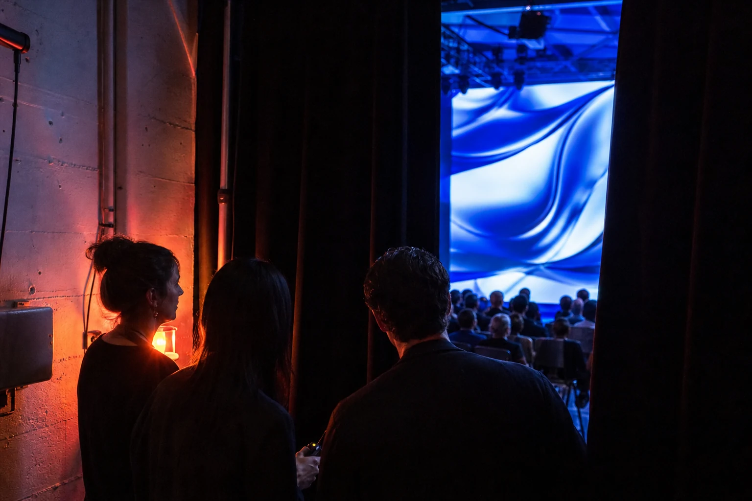 Backstage launch scene with projection light, cables, team silhouettes, and a prepared audio cue