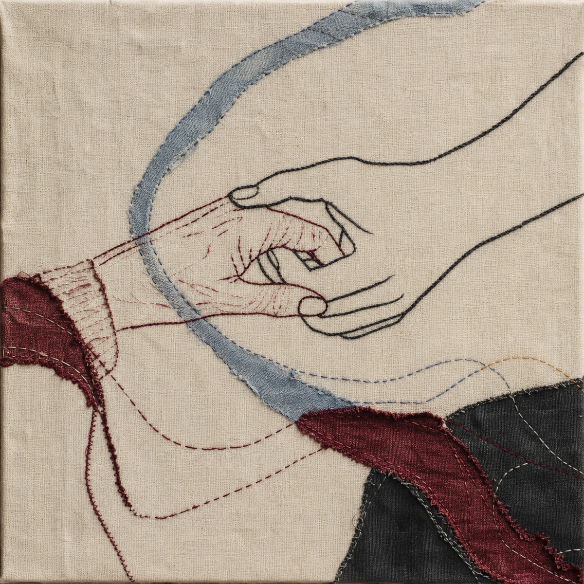 Embroidered fabric artwork of two generations of hands in warm gray and oxblood