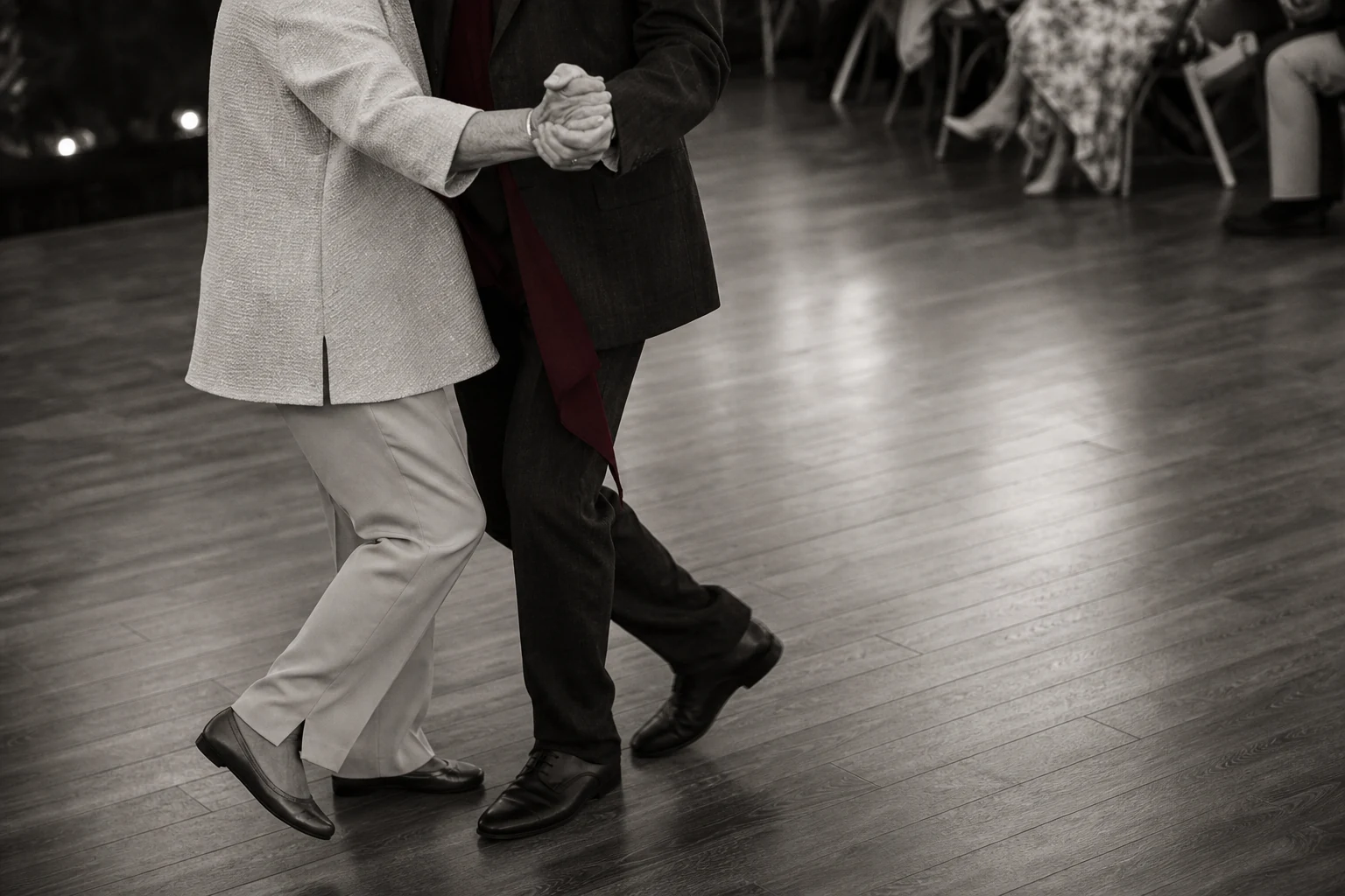 Black-and-white documentary close-up of parent and adult child hands and dance steps