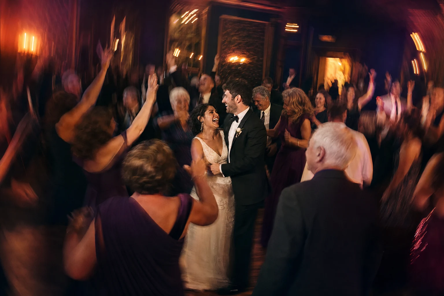 Wedding guests cheering in a slow-shutter reception photograph