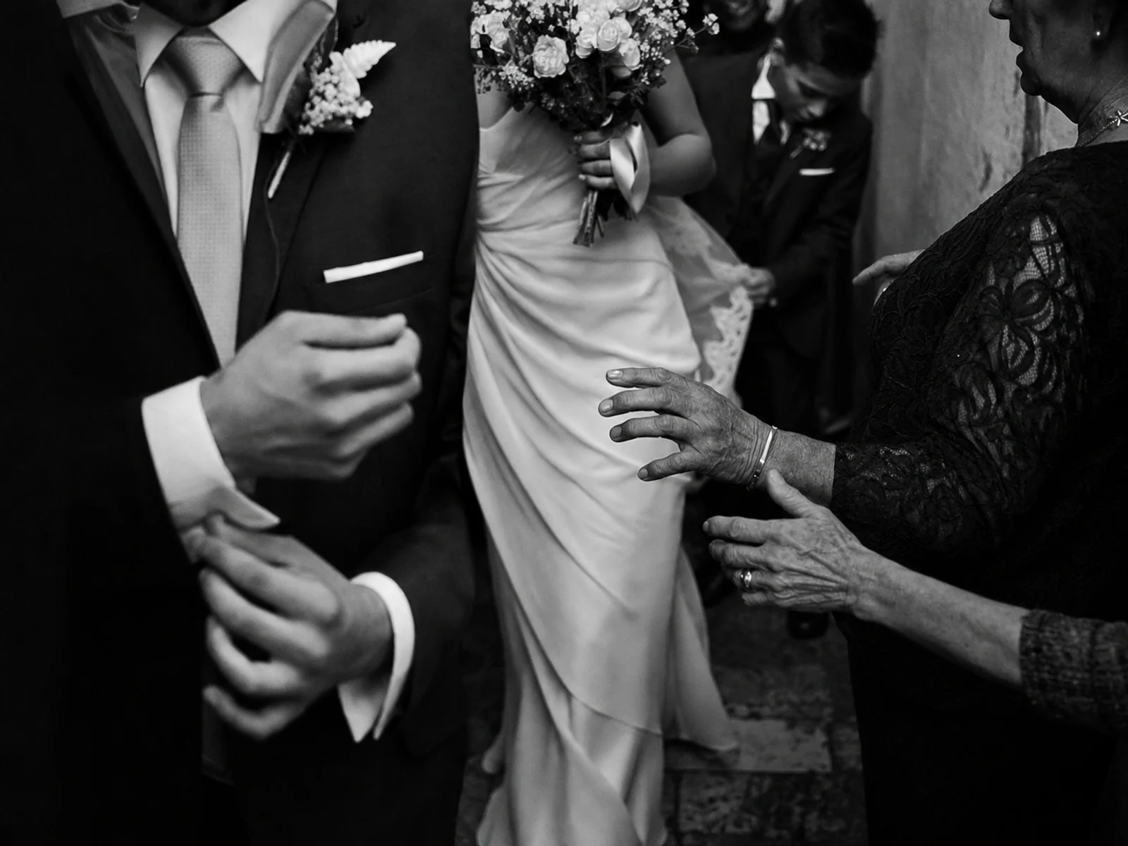 Black-and-white documentary photograph of a wedding procession in motion