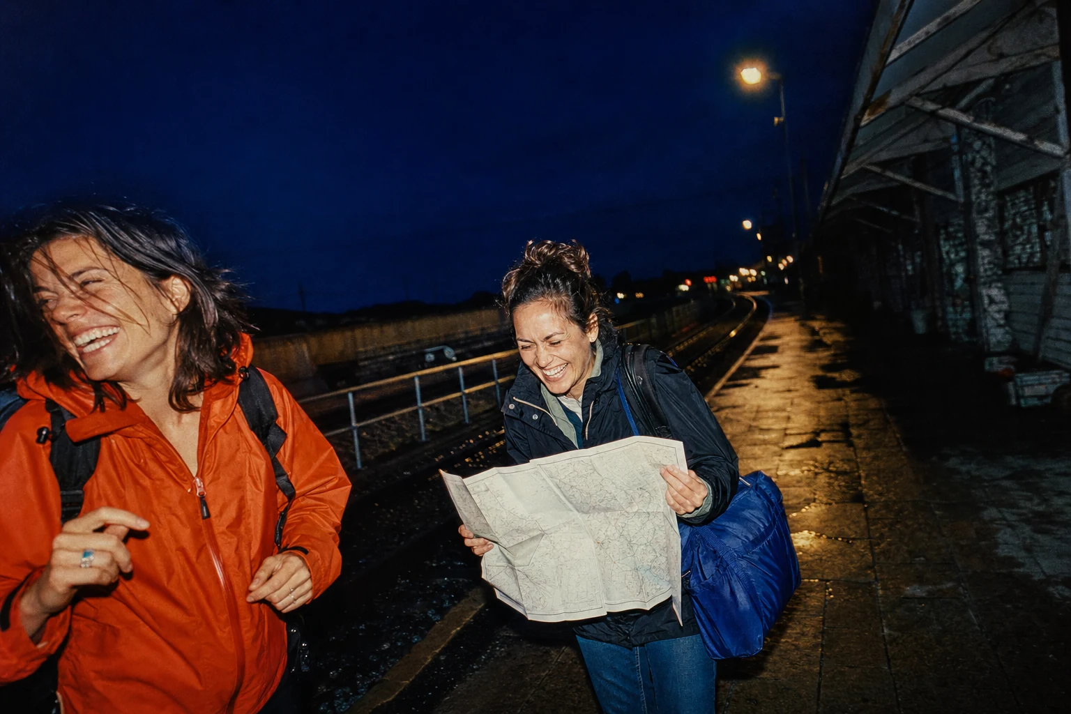Direct-flash travel photograph of best friends in cobalt, orange red, and silver