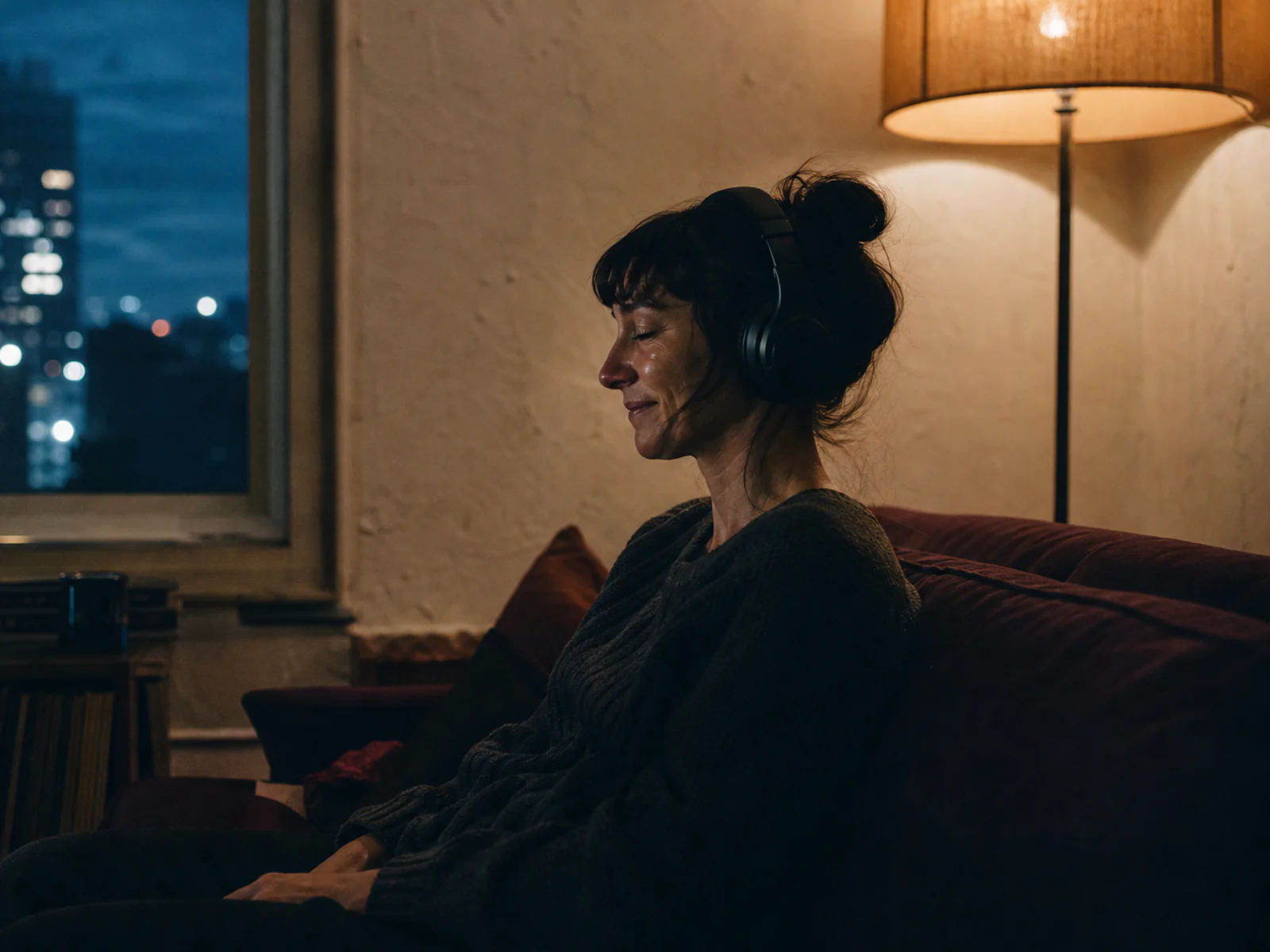 A private listening moment lit by warm tungsten light and cool blue shadows